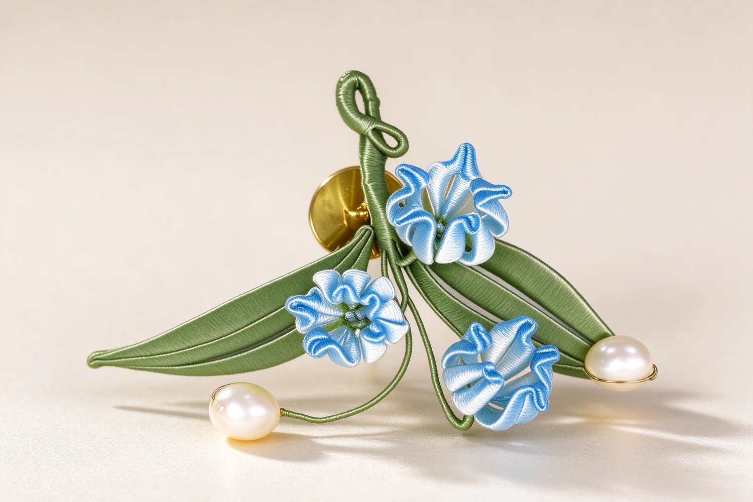 Close-up of the wrapped silk petals and pearl centre on the lily of the valley brooch