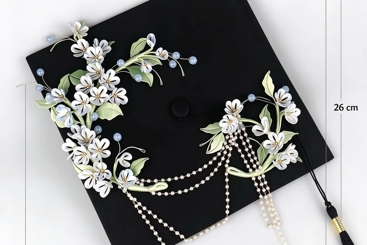 The graduation cap decoration shown against a size reference